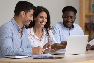 Happy diverse business team sharing laptop computer, watching online project presentation together,...