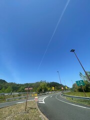 快晴の空に飛行機雲と新緑　京都縦貫道南丹PA