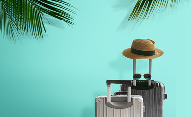 Silver color travel bag with handle and straw hat isolated on blue background.