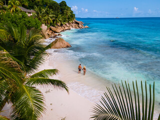 Anse Patates, La Digue Seychelles, a young couple of men and women on a tropical beach during a...