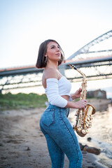Woman playing the saxophone at sunset.