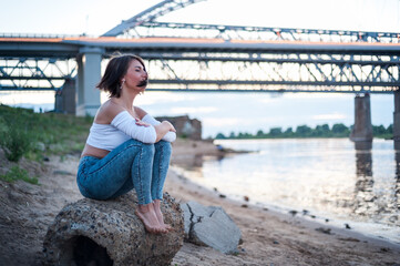 Girl walking on the beach, against the sunset.