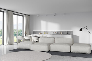 Light kitchen interior with couch, eating table and kitchenware, panoramic window