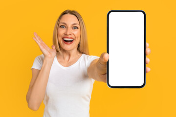 Happy surprised excited pretty millennial european blond woman in white t-shirt show smartphone...