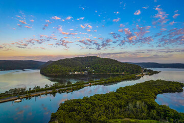 Sunrise waterscape with scattered clouds and reflections