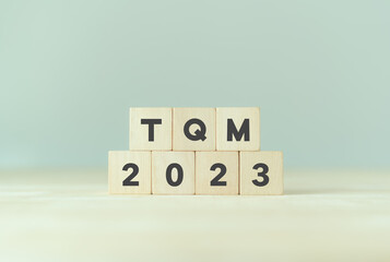 2023 TQM planning, Total quality management concept. Management approach to long-term success through customer satisfaction and sustainability. Wooden cubes with TQM 2023 on smart background.