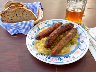 Bratwurst mit Sauerkraut, Brot und Bier