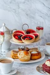 Selection of gourmet cakes with coffee and sparkling wine on a table