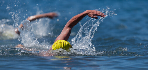 Triathlon swimmers churning up the water two swimmers in races in triathlon