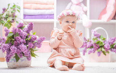 baby with lilac flowers at home or kindergarten