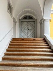 wooden staircase and front door to the building