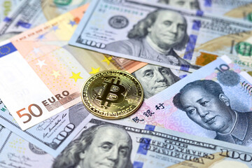 Bitcoin on US dollars, Chinese yuan and Euro banknotes. Concept of electronic decentralized money, crypto currency, global trade and economy