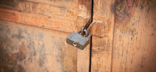 Metal padlock on the metal door.