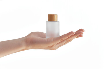 female hand holds a bottle of frosted glass, isolate on a white background, cosmetics, hygiene and skin care concept