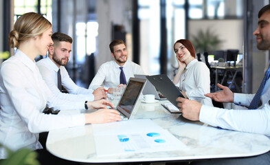 Team of business people having discussion at table in creative office.