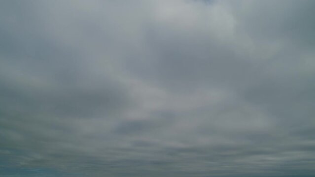 Overcast clouds dissipate into clear blue skies. Weather change. Time lapse.