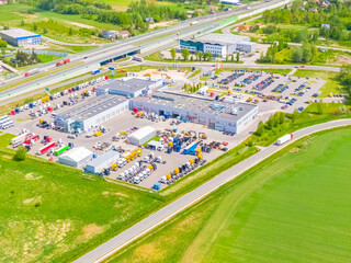 Aerial view of goods warehouse. Logistics center in industrial city zone from above. Aerial view of trucks loading at logistic center