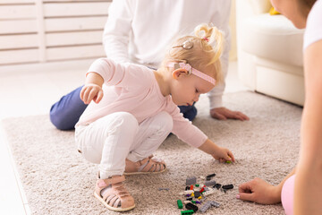 Cochlear implant on the child girl head and playing with mother and father. Hearing aid and...