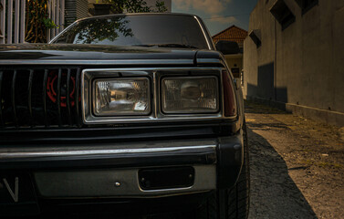 Obraz premium Close-up photo of a beautiful black classic car headlamp.