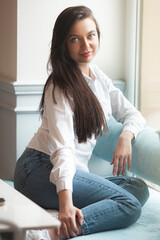 Closeup portrait of young lady indoors. Woman in cafeteria. Attractive brunette woman.