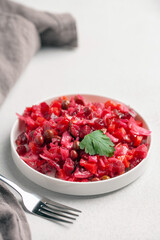 Salad vinaigrette with beets and vegetables on a plate on the table. Healthy diet