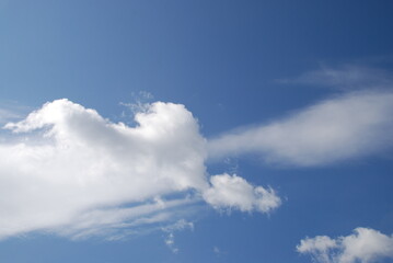 Layered clouds against the sky. Multilevel white clouds are floating in the light blue sky. Clouds of different shapes and sizes are illuminated by the sun and they are fluffy in appearance.