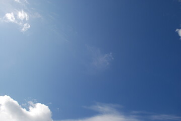 Layered clouds against the sky. Multilevel white clouds are floating in the light blue sky. Clouds of different shapes and sizes are illuminated by the sun and they are fluffy in appearance.