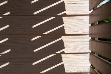 Beige wooden walls and sunshades are made in conjunction with light and shadow.