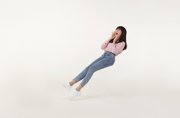 Young beautiful smiling asian girl floating in mid-air shout story and announcement something...