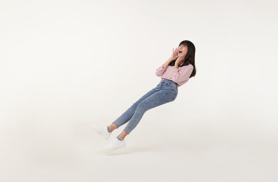 Young Beautiful Smiling Asian Girl Floating In Mid-air Shout Story And Announcement Something Isolated On White Background.