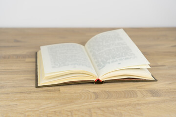 Open book lying on wooden table.