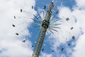 High up in the sky, people ride a carousel in an amusement park