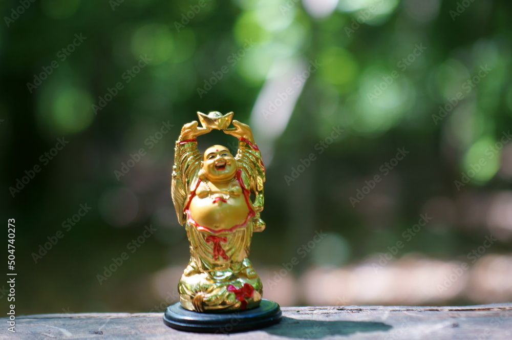 Wall mural Buddha figurine on a colored background close-up.