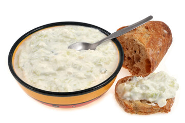 Ramequin de tzatzíki maison posés avec une tranche de pain sur fond blanc