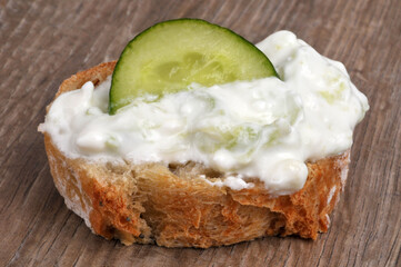Tartine de pain avec du tzatzíki et une rondelle de concombre en gros plan