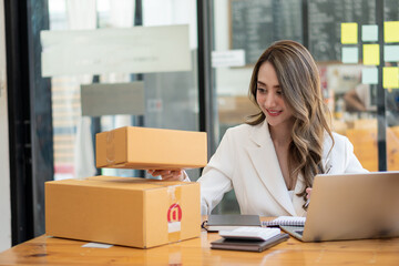 Starting a Small Business, SME Entrepreneur or Freelance Asian Woman Using Laptop for Work, Successful Asian Woman with Box Delivery Business, Online Marketing and Delivering, SME Concepts.