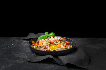 Pasta seafood. Pasta Spaghetti with shrimp, cream sauce and basil. Top view on black wooden table.