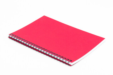 Spiral notebook with red cover on white background