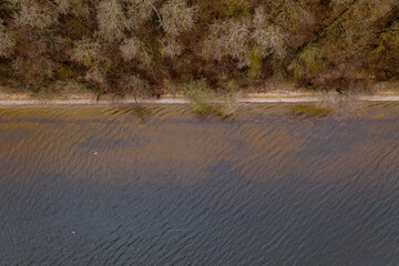 Drone photography of a lake shoreline and forest.