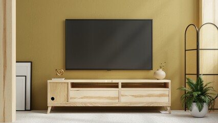 TV on cabinet in modern living room with plant on yellow wall background.