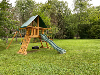  wood backyard playset with wave slide, two clubhouses, rock climbing wall, swings with tire swing, an access ladder
