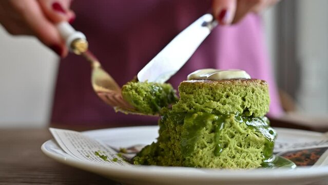 Someone taking a bite of Matcha scone with fork.