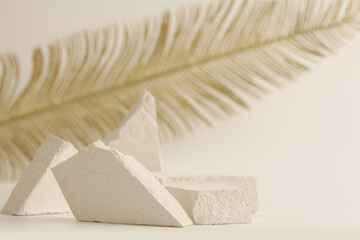 Empty eco stack of stones platform podium and gold leaf on beige background. Minimal stil life...