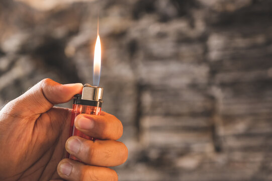 Close Up Hand Man With Lighters Kindle The Fire On Burning Background.