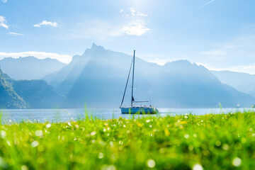 A yacht against the backdrop of the mountains in Switzerland. Calm water and bright sunny day. A...