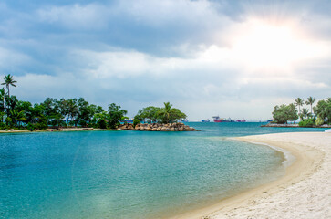 Tropical beach with sand, summer holiday background. Palms and tropical beach with white sand. Sentosa Island, Singapore.