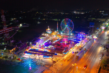 Aerial top view of amusement park in night temple fair, and night local markets. People walking street, Colorful tents in Bangkok city, Thailand. Retail shops