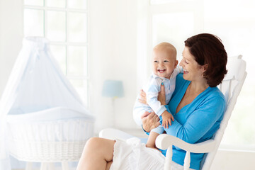 Mother and baby at home. Mom and child in bedroom.