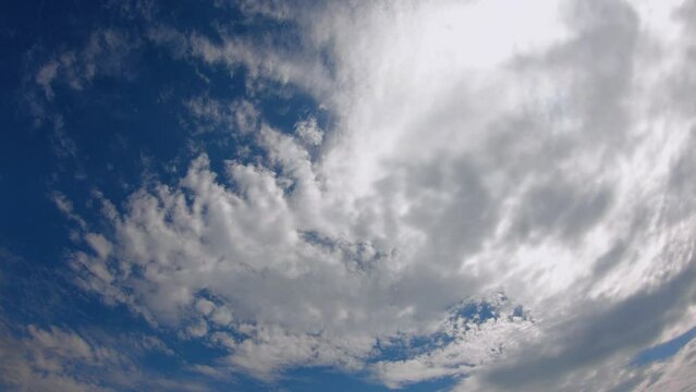 Beautiful white clouds move quickly across the blue sky. Timelapse video. The sky as a background.