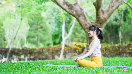 beautiful woman sitting on mat for morning relaxing yoga pose , exercise in park, mental health care, health and sports